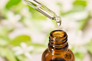 essential oil in the glass dropper, with orange flower background